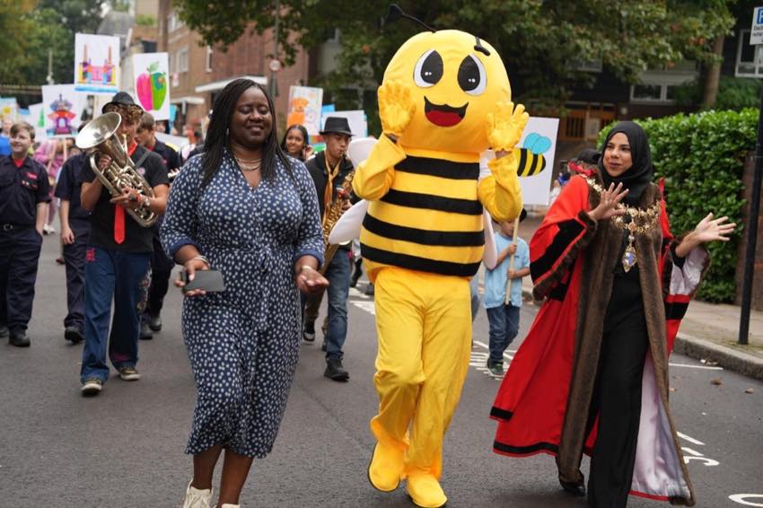 Festival parade with the Battersea bee mascot, local musicians and community leaders.